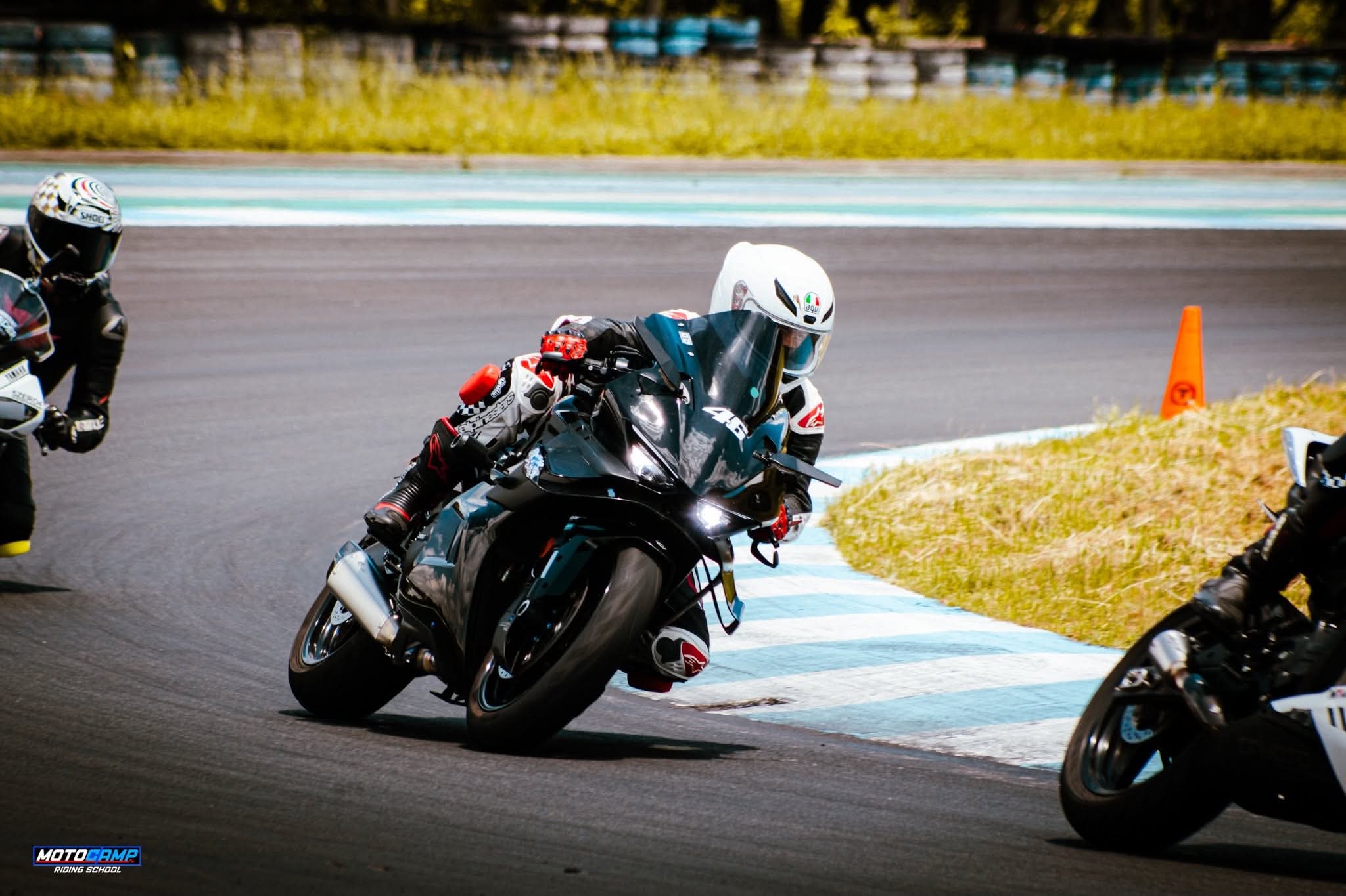 Sport bike leaning through a corner mid-pack