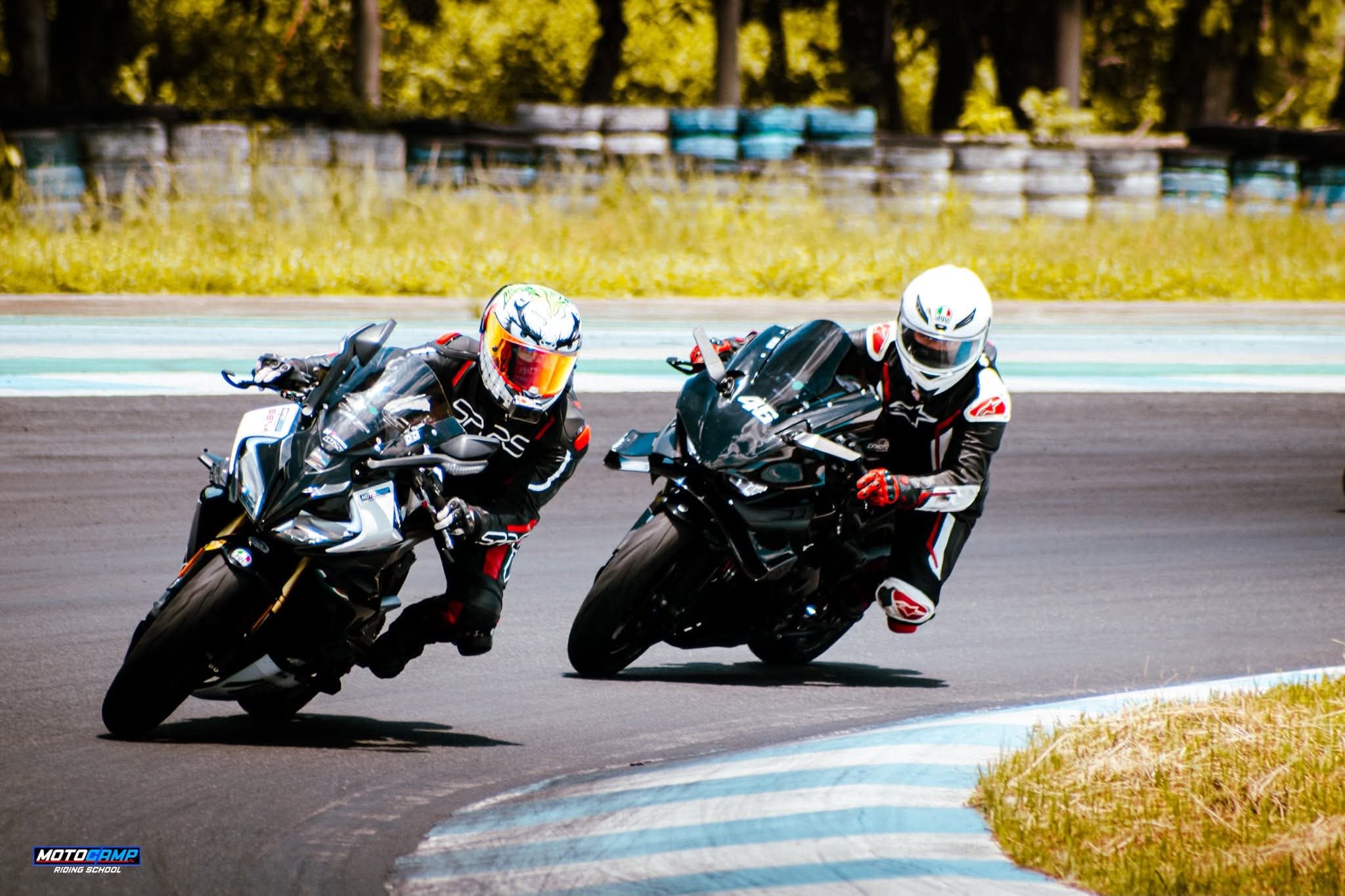 Two riders cornering on track